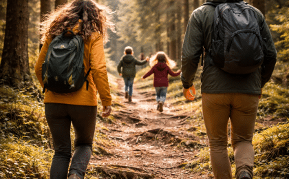 Familie mit zwei Kindern geht in einem Wald spazieren